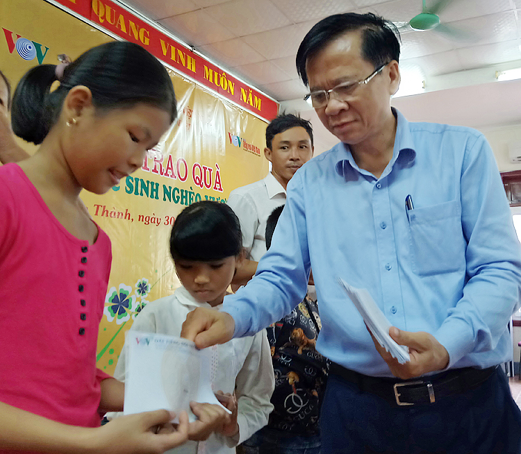Ông Phan Văn Tuyên, Chủ tịch UBND huyện Yên Thành trao quà cho các em học sinh.