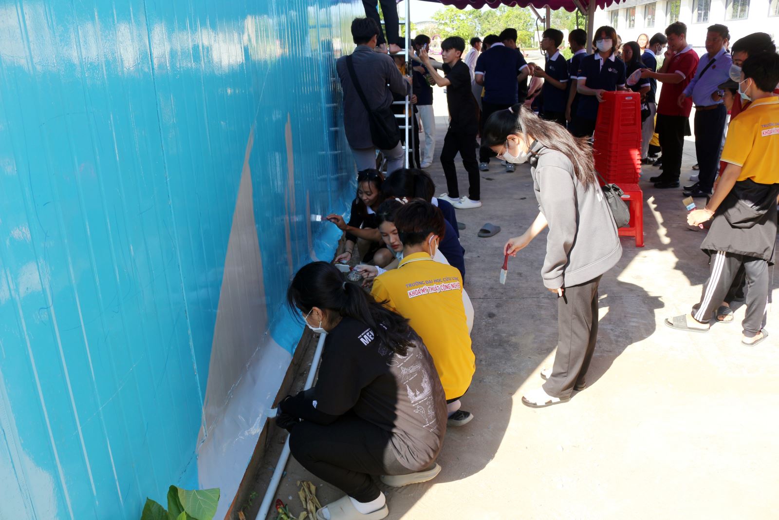 Sinh viên hai trường giao lưu vẽ bức tranh lớn về khuôn viên Trường Đại học Cửu Long.  