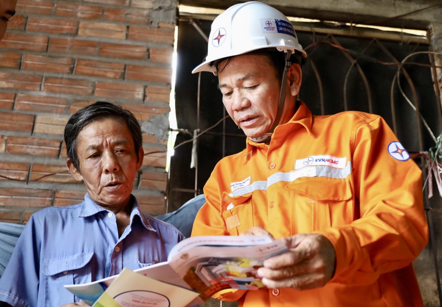 Anh Trương Trọng Nguyên – Công nhân Công ty Điện lực Củ Chi đang tư vấn sử dụng điện an  toàn cho hộ gia đình ông Nguyễn Văn Trung.