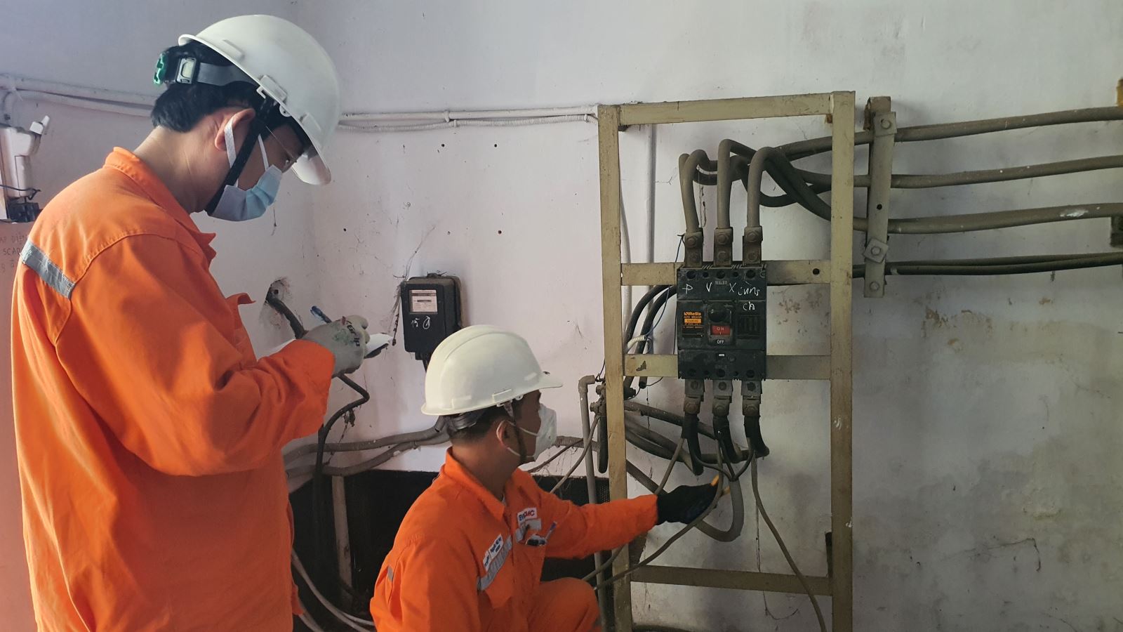 Công nhân EVNHCMC kiểm tra hệ thống điện của khách hàng.