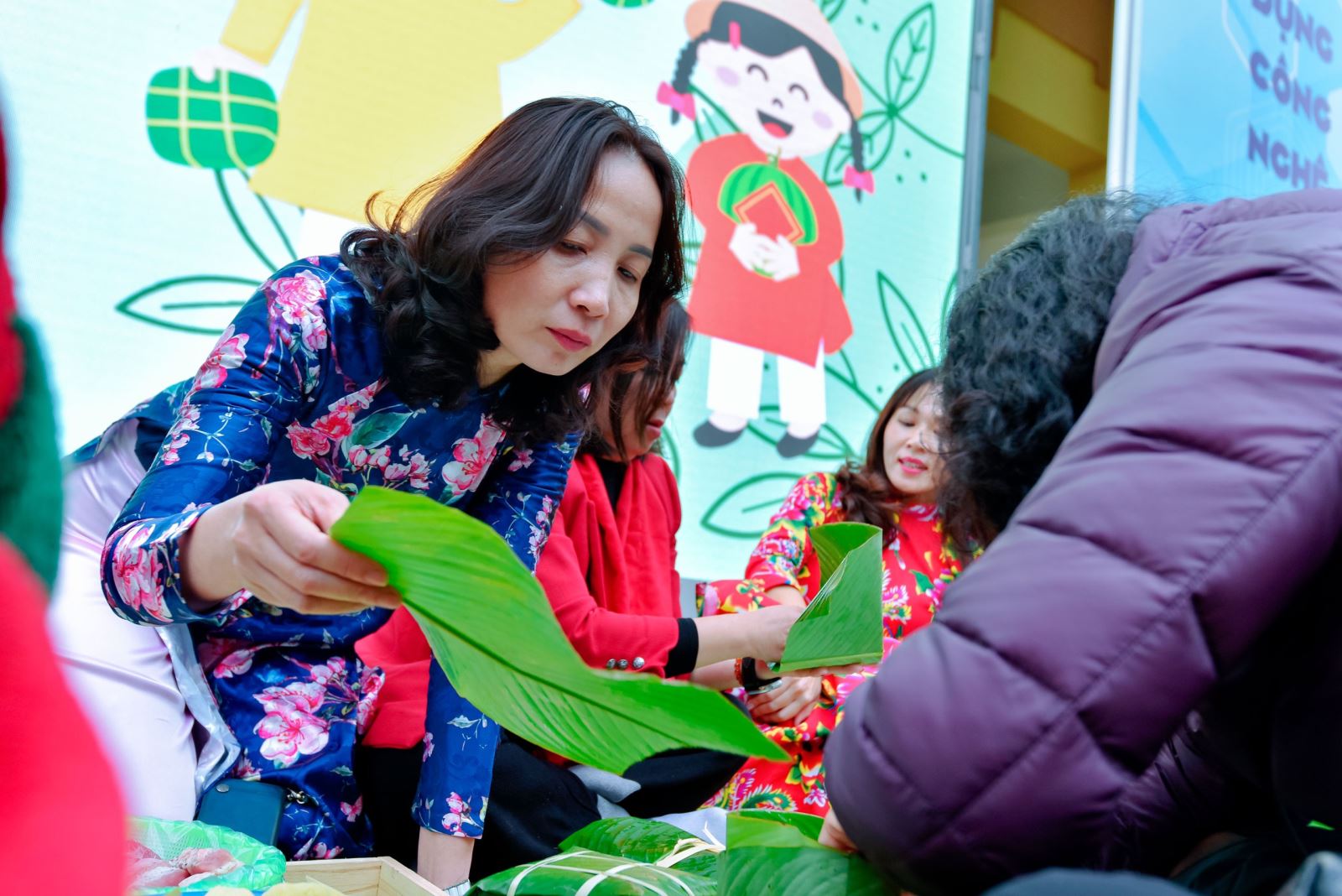 Cô Nguyễn Thị Thu Thủy đồng hành cùng phụ huynh học sinh trong phần thi gói bánh chưng.