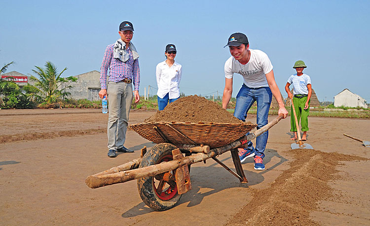 Du khách trải nghiệm nghề làm muối của Diêm dân Hải Thịnh, Nam Định trong một tour du lịch cộng đồng. Ảnh: Thành Công