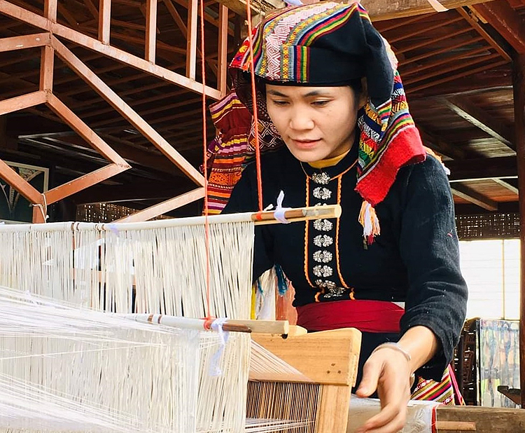 Chị Sầm Thị Tình bên khung dệt thổ cẩm truyền thống của người dân tộc Thái.