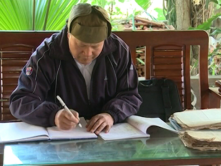 Nghệ nhân dân gian Lò Văn Thắng đang soạn giáo án cho lớp học tiếng Thái. Ảnh: NVCC