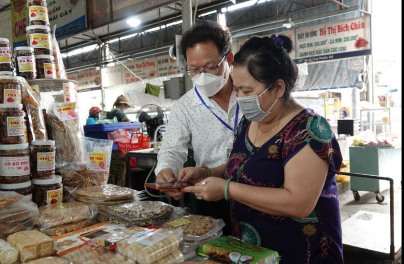 Ban Quản lý các chợ quận Sơn Trà hướng dẫn việc quét mã QR truy xuất nguồn gốc đối với tiểu thương chợ Phước Mỹ.
