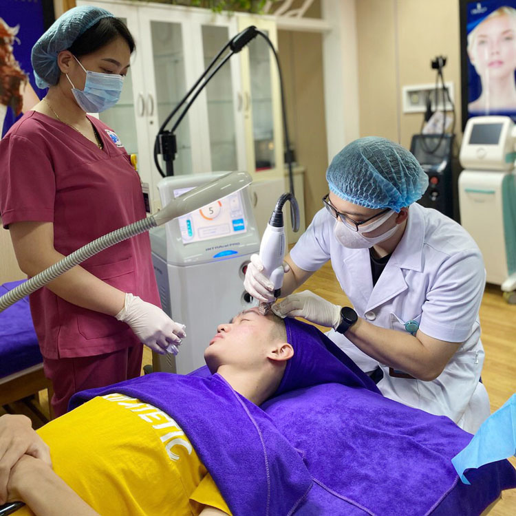 Bác sĩ Nguyễn Quang Minh trị liệu rụng tóc cho người bệnh tại BV Da liễu Trung ương.