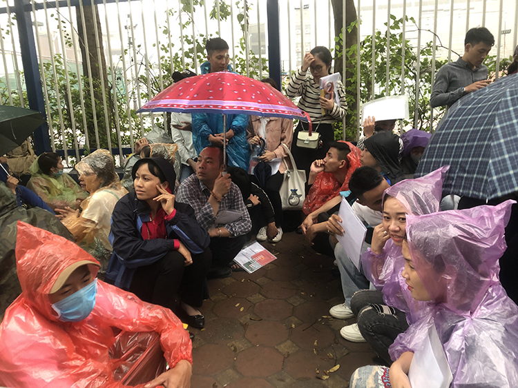 Người dân nhẫn nại đội mưa chờ đến lượt làm visa đi Hàn Quốc