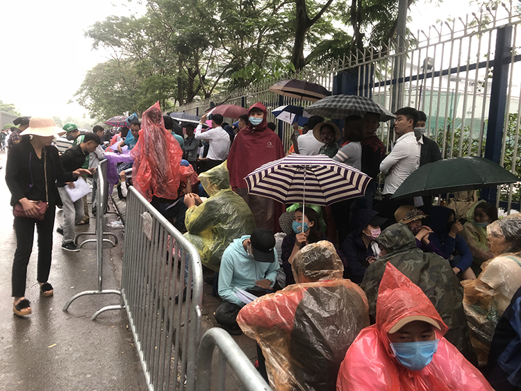 Dù trời mưa, nhưng người dân vẫn chờ đợi làm visa du lịch Hàn Quốc.