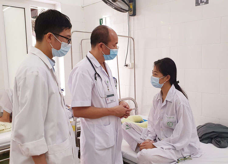 PGS.TS Đỗ Duy Cường (giữa) thăm khám cho người bệnh sốt xuất huyết tại Trung tâm Bệnh nhiệt đới, Bệnh viện Bạch Mai. (Ảnh: KT)