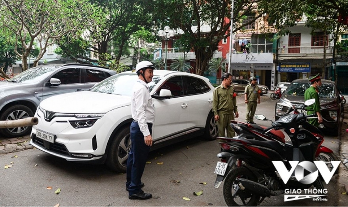  Tại thời điểm kiểm tra, hàng loạt ô tô dừng đỗ 2 bên vỉa hè, cả xuống lòng đường. Ở ngã 3 trước khu nhà vườn A5, trước cửa một Trung tâm dạy tiếng Anh, 2 chiếc xe đỗ song song 2 bên đường, nối tiếp là 2 chiếc xe máy dựng dưới lòng đường “xí chỗ”. (Ảnh: Phúc Tài)