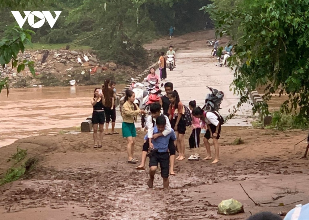 Các thầy, cô giáo cõng học sinh vượt qua đoạn bùn đất lún sâu để đến trường học ở Quảng Bình.