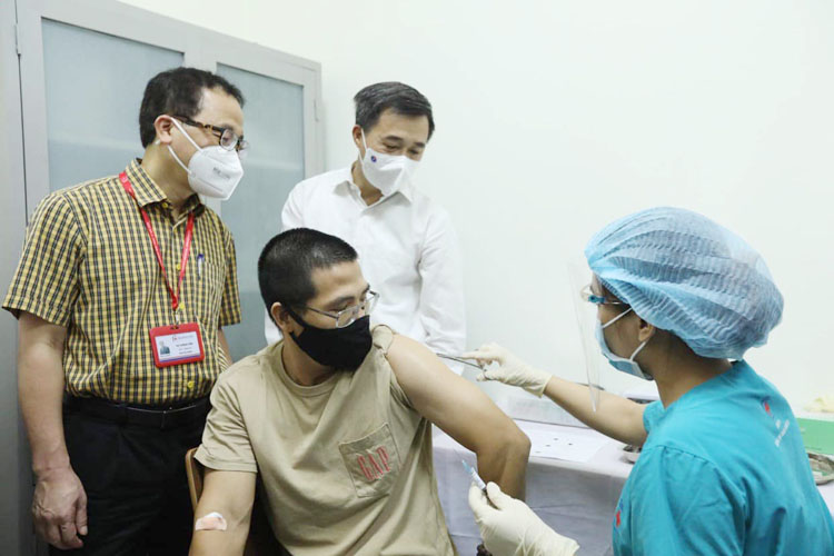 GS.TS Tạ Thành Văn và GS.TS Trần Văn Thuấn chứng kiến mũi tiêm thử nghiệm cho tình nguyện viên đầu tiên. (Ảnh: Nguyễn Quyết)