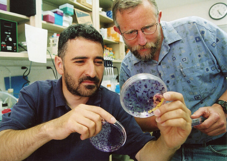 Giáo sư Charles Rice (phải) làm việc tại phòng thí nghiệm với một sinh viên. (Ảnh: KT)