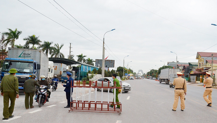 Lực lượng chức năng thực hiện nhiệm vụ chống dịch tại chốt kiểm soát cầu Vàng Chua, xã Bình Dương, TX Đông Triều. (Ảnh: KT)