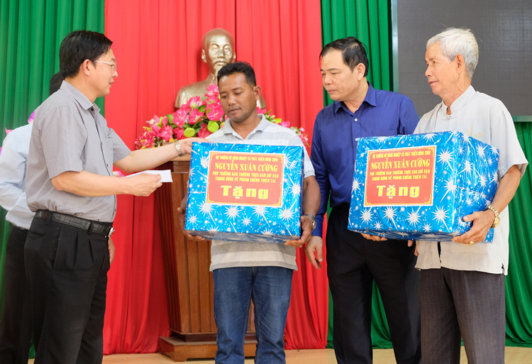 Bộ trưởng Nguyễn Xuân Cường động viên và tặng quà cho thân nhân thuyền trưởng tàu cá BD 97469 còn đang mất tích.
