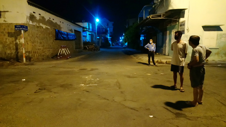 Người dân khu vực phong toả ở Bình Thuận quan sát lực lượng chức năng tháo dỡ barie.