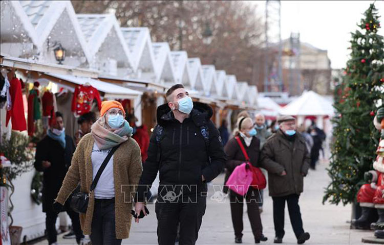 Người dân đeo khẩu trang phòng dịch COVID-19 khi thăm khu chợ Giáng sinh tại Paris, Pháp ngày 9/12/2021. (Ảnh: THX/TTXVN)