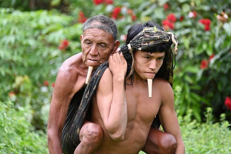 Chàng thanh niên thổ dân cõng cha đi tiêm ngừa COVID-19 ở Amazon, Brazil. (Ảnh: BBC)