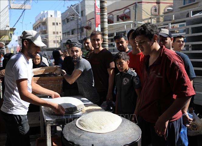 Người dân xếp hàng chờ nhận thức ăn cứu trợ tại dải Gaza ngày 15/10/2023. (Ảnh: THX/TTXVN)