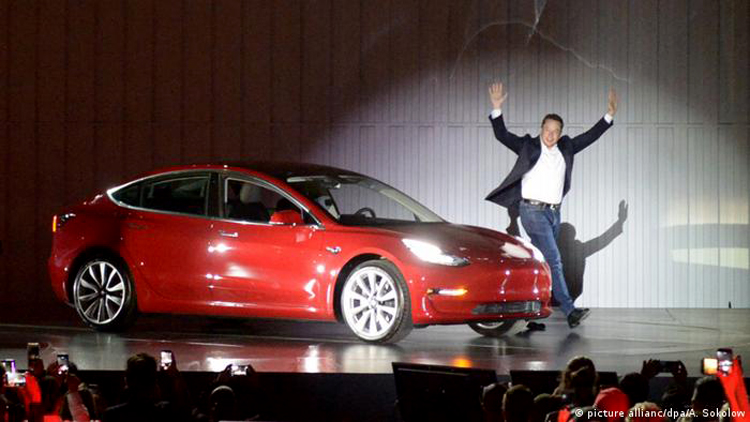 Elon Musk và những chiếc xe điện mang lại cho ông bạc tỷ. (Ảnh: DW)