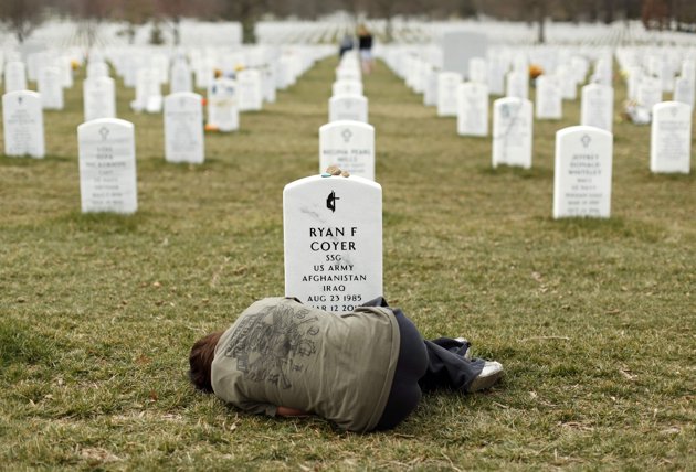 Lesleigh Coyer, 25 tuổi ở Saginaw, Michigan, nằm trước ngôi mộ của anh trai mình, Ryan Coyer, người đã phục vụ cho quân đội Mỹ ở cả Iraq và Afghanistan, tại Nghĩa trang Quốc gia Arlington ở Virginia ngày 11/3/2013. (Ảnh: KT)
