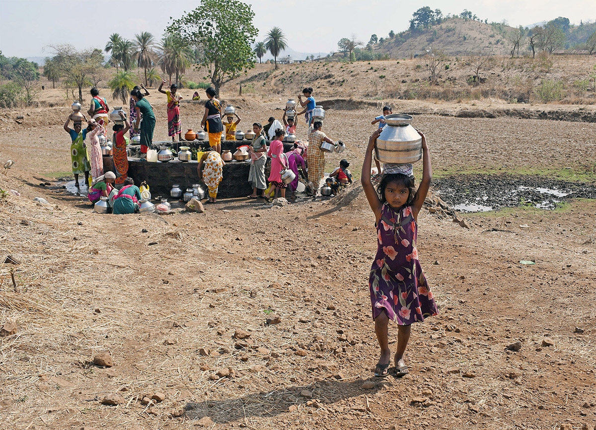 Một em nhỏ ở ngôi làng gần thị trấn Shahapur, quận Thane, bang Maharashtra, Ấn Độ đội bình đựng nước lấy từ giếng trong vùng. (Ảnh: ANI)