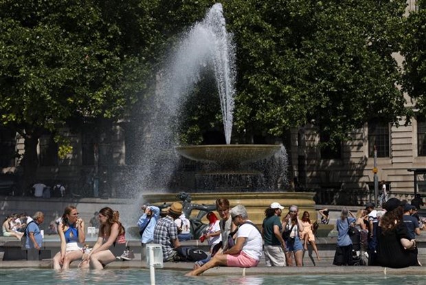 Người dân làm mát tại đài phun nước ở thủ đô Paris, ngày 18/6/2022. (Ảnh: AFP/TTXVN)