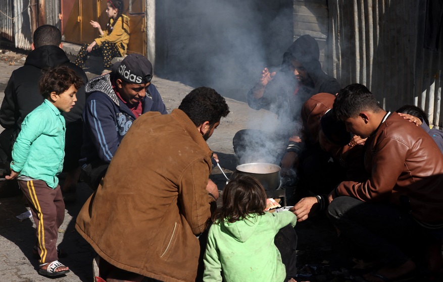 Người dân sơ tán từ Khan Younis đến Rafah nấu ăn trên đường phố. (Ảnh: AFP)