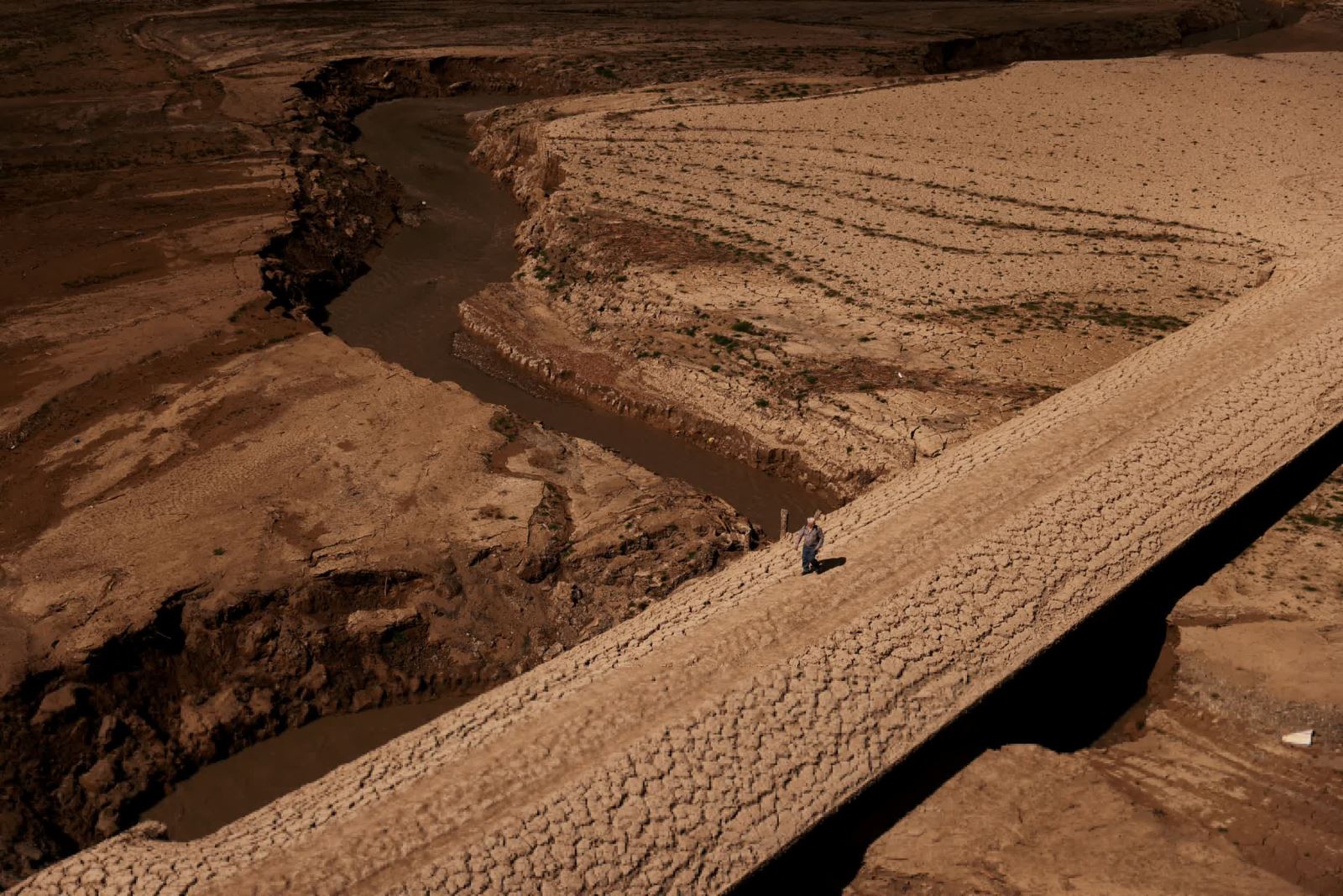 Một người đàn ông bước đi trên mặt đất nứt nẻ của hồ chứa Baells ở làng Cersc, Tây Ban Nha. Bức ảnh của Nacho Doce chụp cho hãng Reuters là một trong những minh chứng cho hệ luỵ của biến đổi khí hậu ngày càng tồi tệ trên khắp toàn cầu.