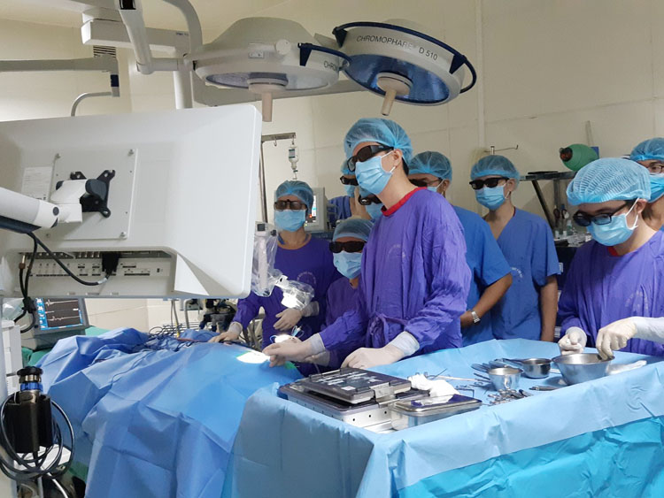 PGS.TS.BS Cao Minh Thành (ngồi giữa 2 người đứng) cùng ekip thực hiện ca phẫu thuật ốc tai điện tử tại BV Đại học Y Hà Nội.