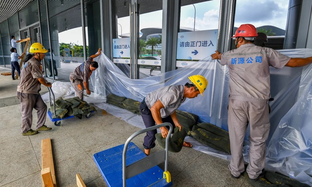 Công nhân Trung Quốc chằng chống cửa kính, đặt bao cát ứng phó siêu bão Yagi sắp đổ bổ vào đảo Hải Nam. (Ảnh: VCG)