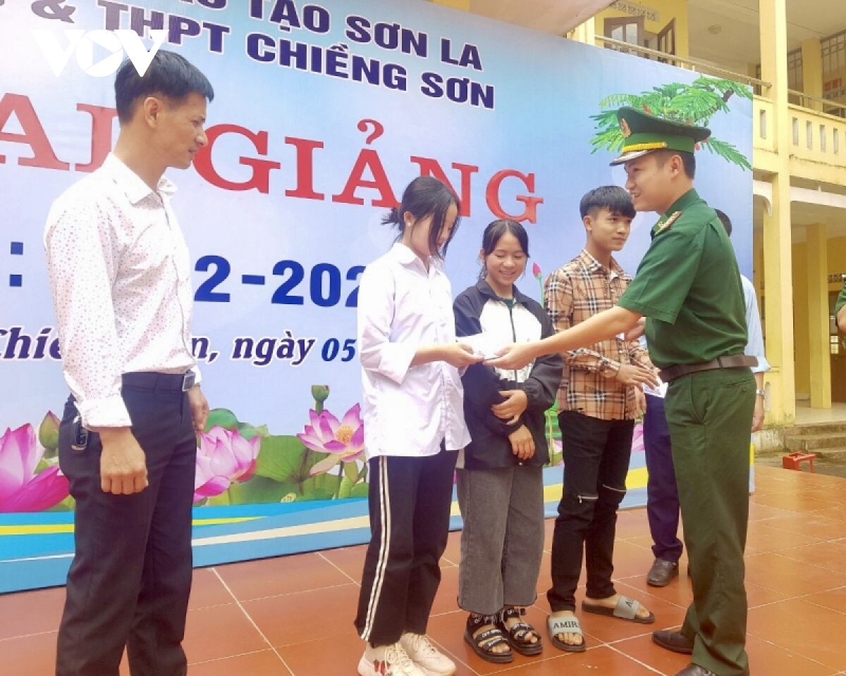 Đại úy Cầm Bá Thành, Chính trị viên phó Đồn Biên phòng cửa khẩu Lóng Sập, huyện Mộc Châu trao suất học phí cho Tráng Thị Tro.