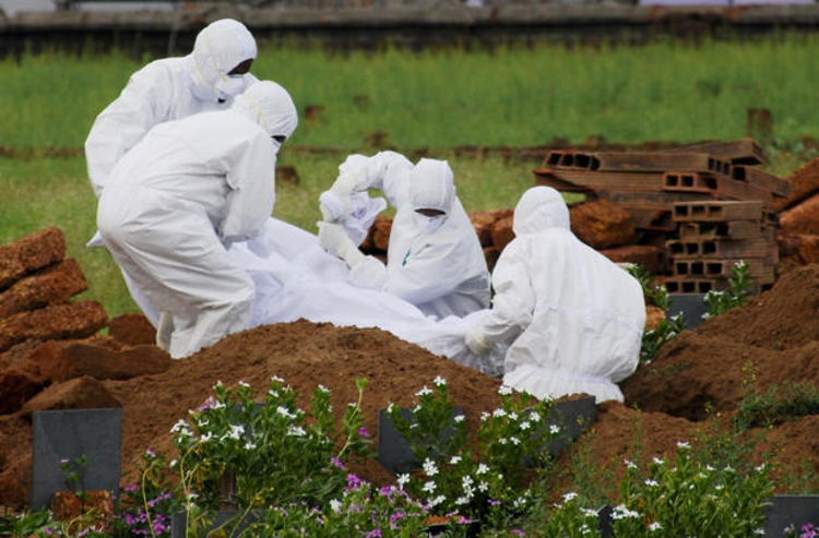 Các nhân viên y tế chôn cất thi thể của bệnh nhân tử vong do virus Nipah, ở Kozhikode, bang Kerala, miền Nam Ấn Độ. (Ảnh: AP)