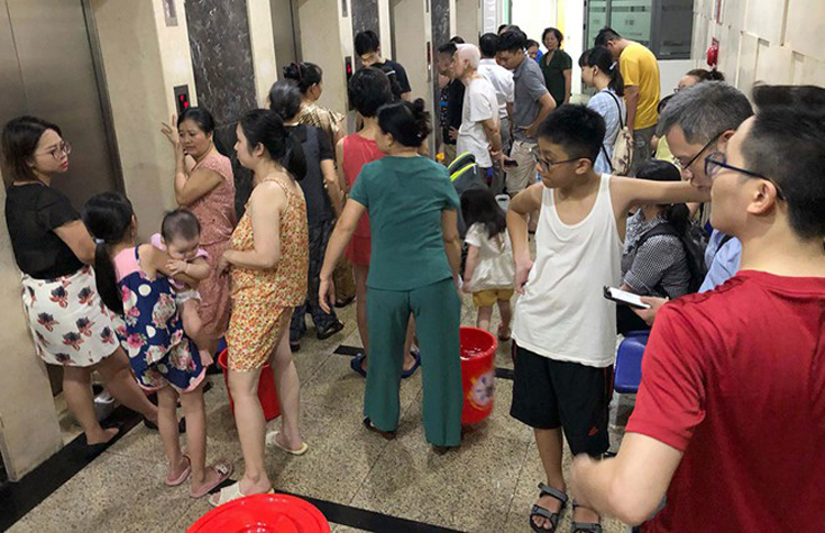 Trong ảnh là người dân chung cư HUD3 Linh Đàm dùng xô, thùng chuyển nước từ xe téc lên căn hộ qua đường thang máy (Ảnh: TN)