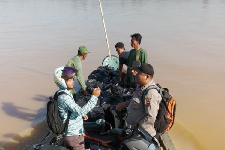 Nhân viên kiểm soát bầu cử cùng cảnh sát địa phương dùng thuyền đi phân phối hậu cần cho các điểm bầu cử bị lũ lụt tại tỉnh Jambi (Nguồn: Ủy ban bầu cử tỉnh Jambi/ Antaranews) 