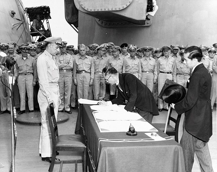 Ngoại trưởng Nhật Bản Mamoru Shigemitsu ký văn kiện Nhật Bản đầu hàng trên tàu USS Missouri với sự giám sát của tướng Richard K. Sutherland, 2 tháng 9 năm 1945.