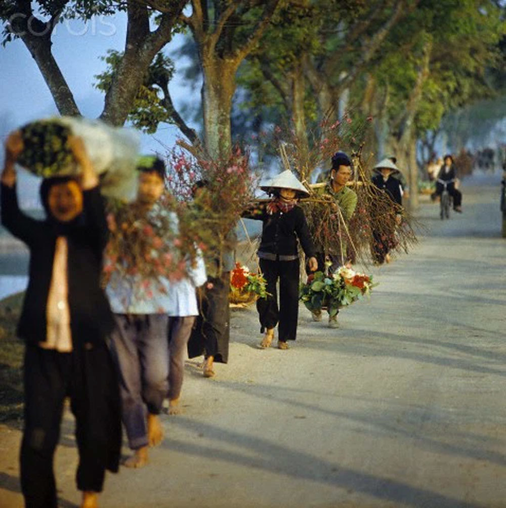 Người dân vui vẻ trở về từ chợ hoa Nghi Tàm sau khi đã sắm đồ Tết chuẩn bị cho năm mới 1973. (Ảnh: KT)