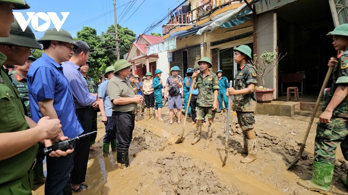 Thủ tướng thăm hỏi các chiến sĩ làm nhiệm vụ dọn bùn đất ở thành phố Yên Bái. 