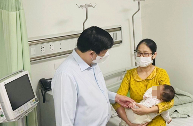 Bộ trưởng Bộ Y tế Nguyễn Thanh Long thăm, trò chuyện với gia đình cháu bé bị tiêm nhầm vaccine đang theo dõi sức khoẻ tại Bệnh viện Xanh Pôn. (Ảnh: T.Q)