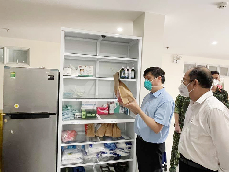 Bộ trưởng Bộ Y tế Nguyễn Thanh Long (bên trái) kiểm tra túi thuốc phát cho F0 tại TP.HCM.