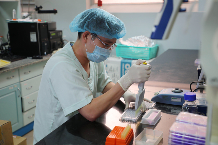 Các nhà khoa học nghiên cứu vắc-xin ngừa Covid-19 tại phòng thí nghiệm.