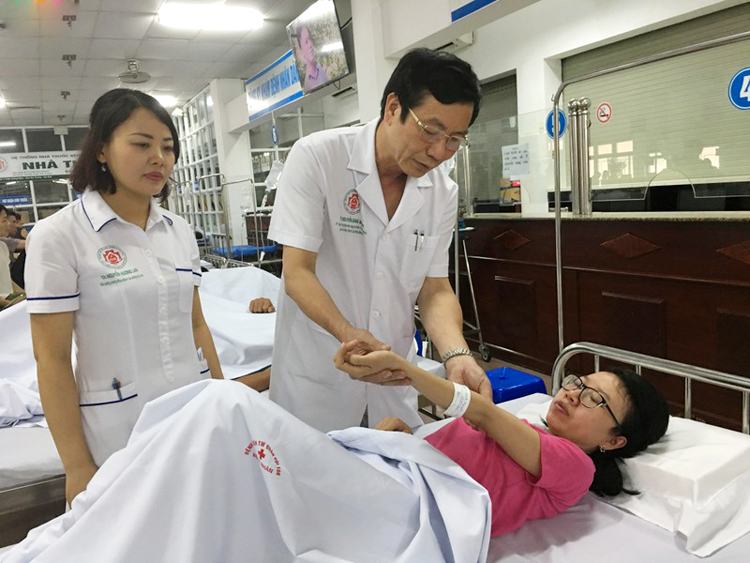TS.BS Nguyễn Đăng Mạnh đang thăm khám cho người bệnh sốt xuất huyết.