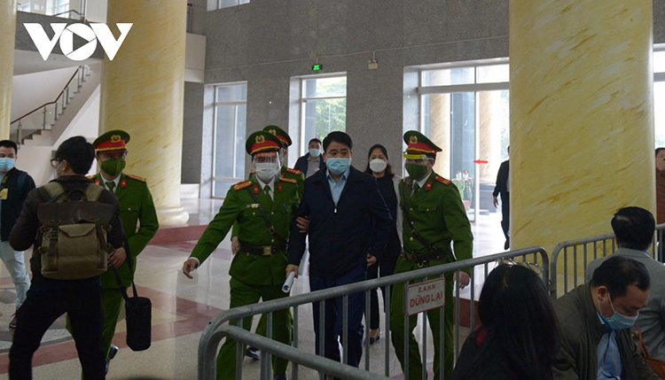 Ông Nguyễn Đức Chung xuất hiện khoẻ mạnh, được cảnh sát dẫn giải vào toà.