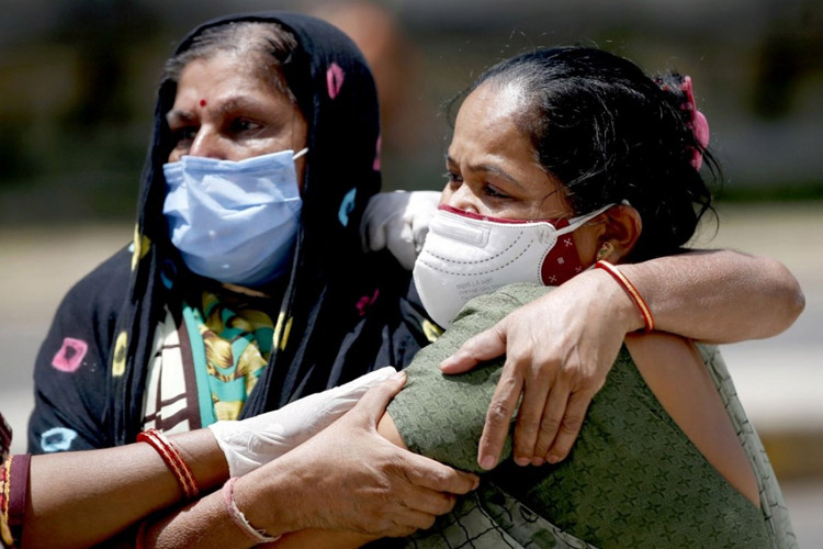 Người thân của một nạn nhân Covid-19 an ủi nhau ở Ahmedabad, Ấn Độ. Ảnh: Tân Hoa xã
