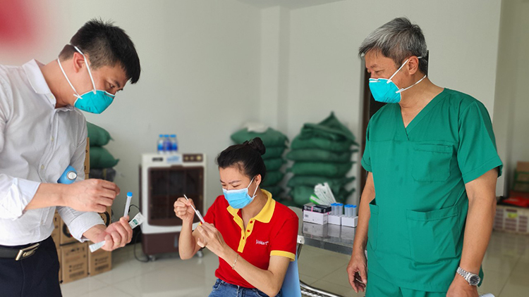 Thứ trưởng Bộ Y tế Nguyễn Trường Sơn theo dõi việc hướng dẫn người dân tự lấy mẫu xét nghiệm Covid-19 (Ảnh Bộ Y tế)
