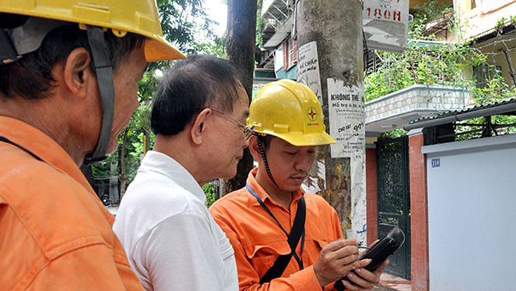 Nhân viên điện lực cùng người dân kiểm tra chỉ số công tơ điện.