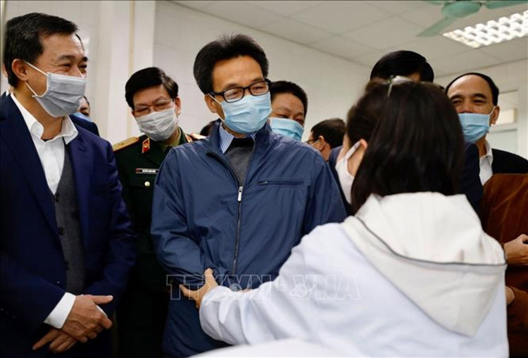 Phó Thủ tướng Vũ Đức Đam thăm hỏi, động viện các tình nguyện viên thử vaccine tại Việt Nam. Ảnh: TTXVN
