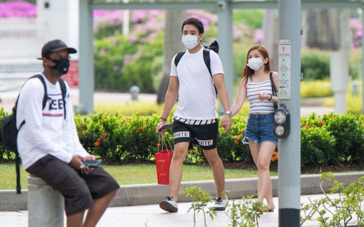 Người Singapore đeo khẩu trang đối phó với bệnh Covid-19. Ảnh chụp bên ngoài tòa nhà Quốc hội Singapore. Ảnh: Yahoo News.
