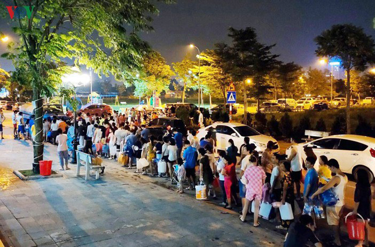 Người dân à Nội thwucs cả đêm xếp hàng chờ xin nước từ xe bồn do sự cố nước sông Đà bị nhiễm bẩn.