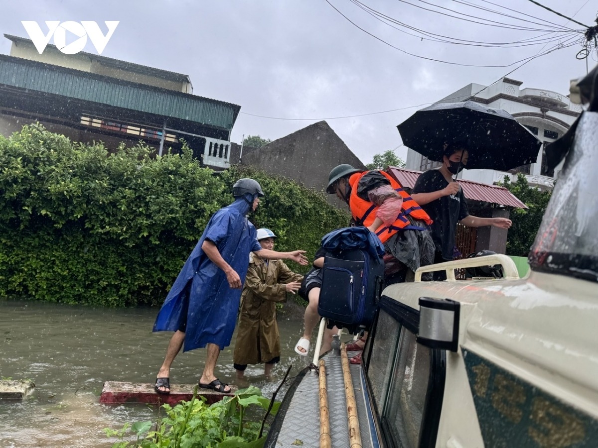 Cán bộ, chiến sĩ Bộ CHQS tỉnh Bắc Ninh hỗ trợ người dân xóm Soi ra khỏi vùng lũ.